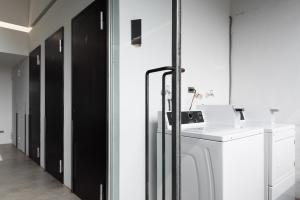 a laundry room with a washer and dryer and black doors at 軟寓 nńg inn in Tainan