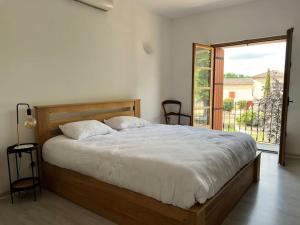 ein Schlafzimmer mit einem großen Bett und einem großen Fenster in der Unterkunft Petit coin de paradis Albigeois in Castelnau-de-Lévis