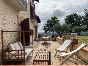 eine Terrasse mit Stühlen, einem Sofa und einem Tisch in der Unterkunft Petit coin de paradis Albigeois in Castelnau-de-Lévis