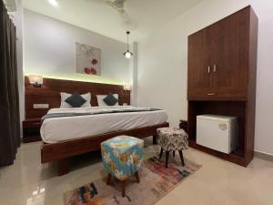 a bedroom with a bed and two chairs in it at Baga Keys by RJ14 in Old Goa