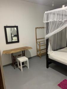 a bedroom with a bed and a table and a desk at Sonya Garden View in Weligama +12 photos