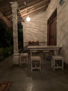 a picnic table and stools in a room at Sonya Garden View in Weligama