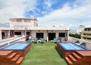 a rooftop patio with two pools on a building at Dynasty Inn Pattaya in Pattaya