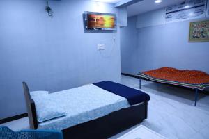Habitación hospitalaria con 2 camas y TV en HOMESTAY ( EAGLE NEST ), en Bhuj