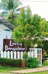a sign for a library building with a white fence at LUCKY Bungalows Koh Mook in Ko Mook