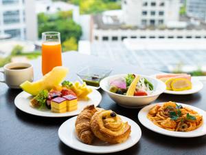 une table avec des assiettes de nourriture sur une table dans l'établissement KOKO HOTEL Premier Kumamoto, à Kumamoto