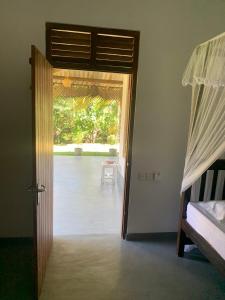 a room with a door open to a bedroom at Sonya Garden View in Weligama