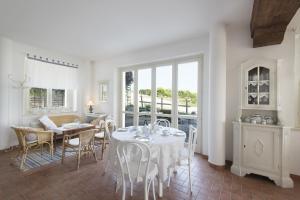 a white dining room with a table and chairs at Agriturismo Albarossa in Nizza Monferrato