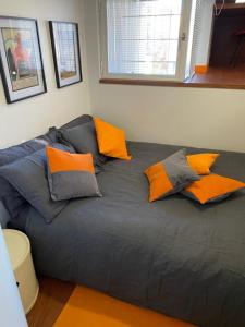 ein Bett mit orangefarbenen und grauen Kissen darauf in der Unterkunft The Serra Vision in Ivrea