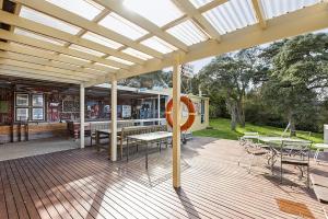 een paviljoen met tafels en stoelen op een houten terras bij Golden Bouy in Point Lonsdale