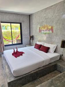 a bedroom with a large white bed with red pillows at Lanta Happy House in Ko Lanta