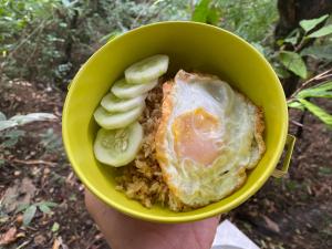 una persona che tiene in mano una ciotola di cibo con uova e verdure di Royal mountain lake view a Ratchaburi