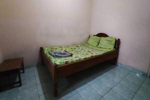 ein kleines Bett in einer Ecke eines Zimmers in der Unterkunft OYO 93395 Pondok Wisata Sekar Kemuning in Yogyakarta