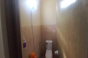 La salle de bains est pourvue de toilettes et d'une lumière sur le mur. dans l'établissement OYO 93395 Pondok Wisata Sekar Kemuning, à Yogyakarta