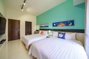 two beds in a room with blue walls at 新森活民宿 in Wujie