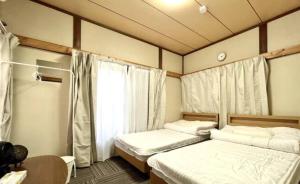 1 dormitorio con 2 camas y ventana en Shinjuku Garden House en Tokio