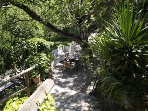 a patio with a table and chairs in a garden at Apartamentos Arroyo Parrilla in La Iruela