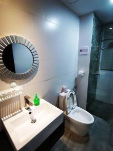 ein Badezimmer mit einem Waschbecken, einem Spiegel und einem WC in der Unterkunft Teo Resident2vivacity jazz 4 in Kuching