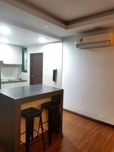 eine Küche mit einem Tisch und 2 Hockern in einem Zimmer in der Unterkunft Teo Resident2vivacity jazz 4 in Kuching