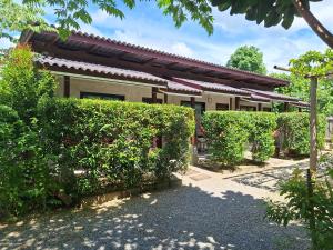 Lanta Happy House في كو لانتا: أمامه منزل به حواف خضراء