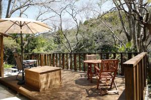 a patio with a table and chairs and an umbrella at かげやんのいえ　KAGEYAN NO IE in Tsu
