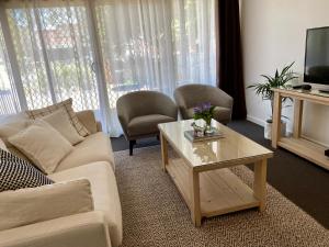 a living room with a couch and a coffee table at Angaston Mews Apartments in Angaston