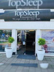 dos macetas en macetas frente a una tienda en TopSleep Apartment 26-1, en Arnhem