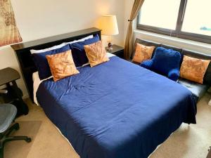 a bedroom with a large blue bed and a couch at Executive Suite at Crystal City - 1BR, Metro, Gym, Free Parking in Arlington
