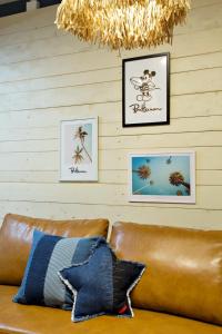 a brown leather couch with three pictures on a wall at クラリス大川 A号室 in Ishigaki Island