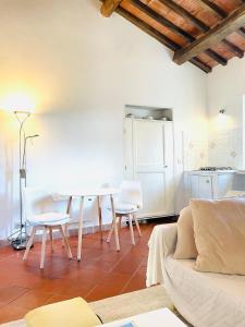 ein Wohnzimmer mit einem weißen Tisch und Stühlen in der Unterkunft Hagakure in Calcata