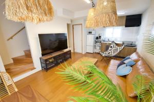 a living room with a couch and a flat screen tv at クラリス大川 A号室 in Ishigaki Island