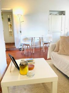 ein Wohnzimmer mit einem weißen Tisch und einem Sofa in der Unterkunft Hagakure in Calcata