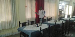Uma mulher está numa sala com mesas. em Hotel Abhashree ,Madhya Pradesh em Betūl