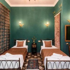 a bedroom with two beds and a green wall at Vorontsoff Inn Boutique Hotel in Tbilisi City