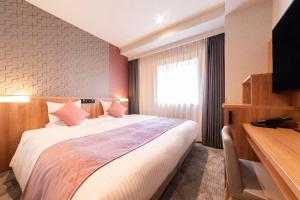 a hotel room with a large bed and a television at ART HOTEL Aomori in Aomori