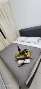 a bed with a tray of food and flowers on it at Legasi Kampung Baru guest house by rumahrehat in Kuala Lumpur