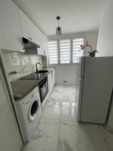 uma cozinha com uma máquina de lavar roupa e um frigorífico em Appartement 2 pieces, salon et chambre, 44m2 refait à neuf em Clichy