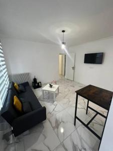 uma sala de estar com um sofá preto e uma mesa em Appartement 2 pieces, salon et chambre, 44m2 refait à neuf em Clichy