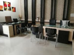 a room with chairs and tables in a building at Hotel IC Inn,Betul in Betūl
