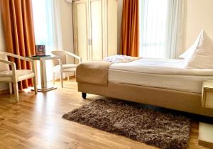 クルジュ・ナポカにあるホテル パラディスのベッドルーム1室(ベッド1台、椅子、テーブル付)