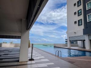 um edifício com piscina junto ao oceano em D'Grand Homestay Tanjung em Kuala Terengganu