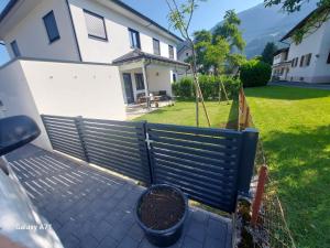 a fence in front of a house with a yard at Unicorn Apartment in Nüziders