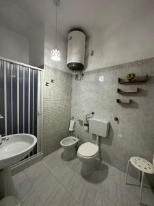 W łazience znajduje się toaleta, umywalka, wanna i toaleta. w obiekcie Giardino dei Baroni house w mieście Marina di Mancaversa