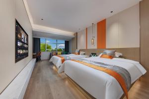 a bedroom with two beds and a flat screen tv at Guangzhou Yachen Hotel in Guangzhou