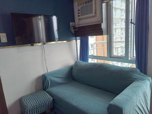 a green couch in a room with a window at Tagaytay Prime Residences with Swimming Pool & Viewing Deck in Tagaytay