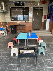 a ping pong table and benches in front of a building at 時空民宿Time and Space in Wujie