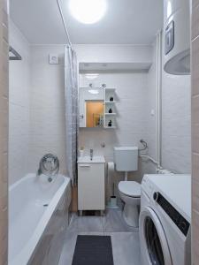 a bathroom with a toilet sink and a washing machine at Apartman Franko - SELF CHECK IN in Osijek