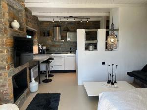 a kitchen and living room with a brick wall at Villa Sandra Maria in Vourkari