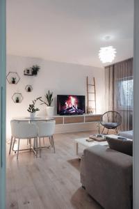 a living room with a couch and a tv on the wall at Apartman Franko - SELF CHECK IN in Osijek