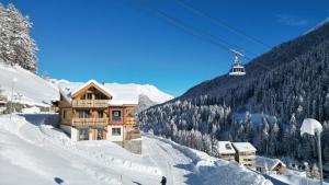 a ski lodge on a snowy mountain with a ski lift at Samnaun, ChaletdMot in Samnaun